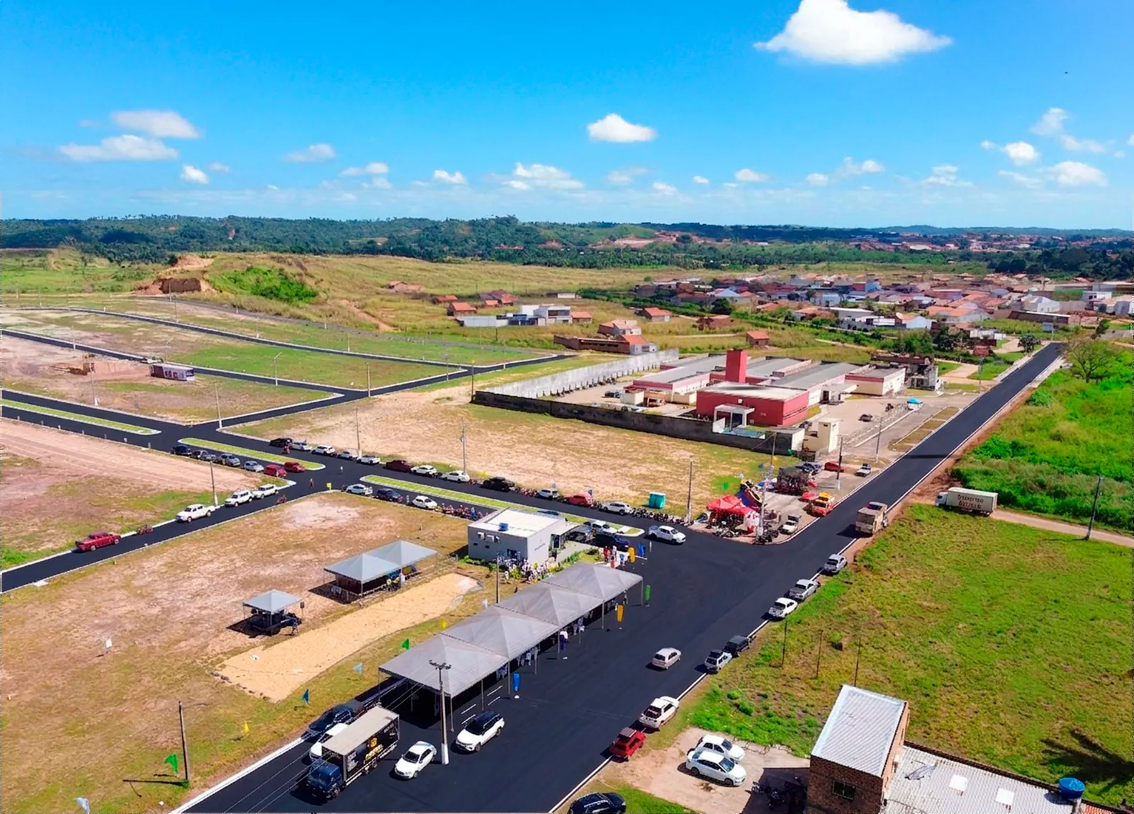 Vista aérea do Mearim Ville com avenidas asfaltadas e estande de vendas
